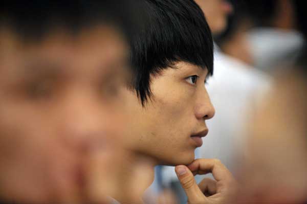 A job applicant concentrates on recruiting information at a job fair held in Haikou, the capital city of South China&apos;s Hainan province, July 13, 2010. [Xinhua]