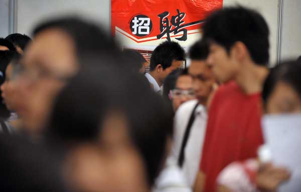 Graduates walk around and search for jobs at a job fair held in Haikou, the capital city of South China&apos;s Hainan province, July 13, 2010. [Xinhua] 