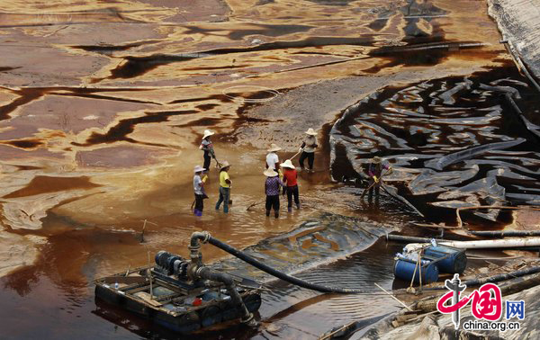 Workers on July 14 clean up a toxic copper spill in the Tingjiang River, a major waterway in Longyan of Fujian province. Pollution from the Zijinshan Copper Mine contaminated the river, leading to the poisoning of up to 1,890 tons of fish. [CFP]