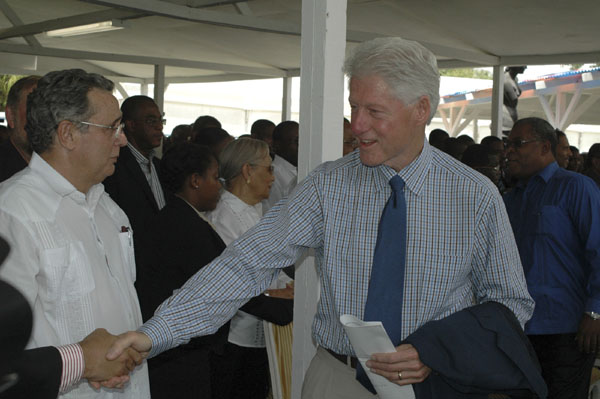 Former U.S. President and U.N. special envoy to Haiti Bill Clinton (R) shakes hands with guests at a news coference in the damaged national palace in Port-au-Prince July 12, 2010. Haiti is commemorating on Monday the six-month anniversary of the disaster that killed more than 300,000 people. [Xinhua] 