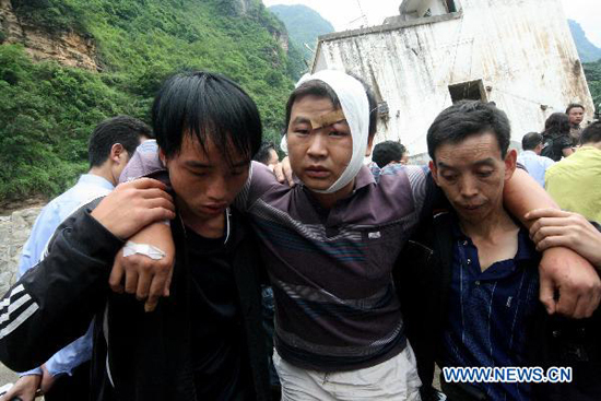 AAn injured man, whose parents and wife are missing, is evacuated in Xiaohe Town of Qiaojia County, southwest China's Yunnan Province, July 13, 2010. 13 people were killed and more than 30 others went missing after landslide and flood hit the town early Tuesday. As of noon, 43 people were also injured in the disaster. 