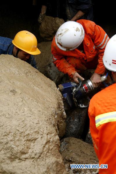 Firemen work on a flooded street in Xiaohe Town of Qiaojia County, southwest China's Yunnan Province, July 13, 2010. 13 people were killed and more than 30 others went missing after landslide and flood hit the town early Tuesday. As of noon, 43 people were also injured in the disaster.