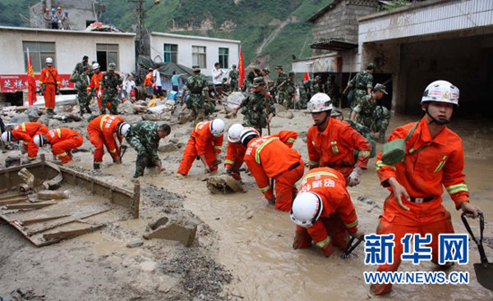 Firemen work on a flooded street in Xiaohe Town of Qiaojia County, southwest China's Yunnan Province, July 13, 2010. 13 people were killed and more than 30 others went missing after landslide and flood hit the town early Tuesday. As of noon, 43 people were also injured in the disaster.