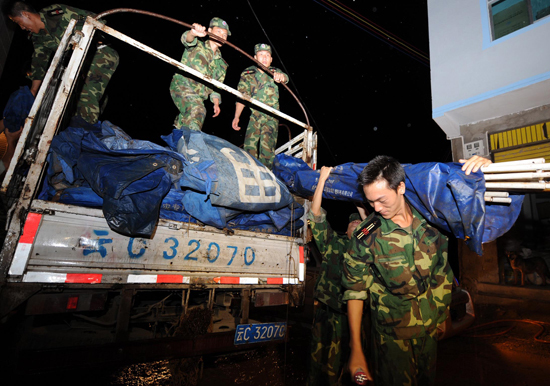 Rescue workers transport relief to the landslide-hit Xiaohe Town of Qiaojia County, southwest China's Yunnan Province, early Tuesday. 