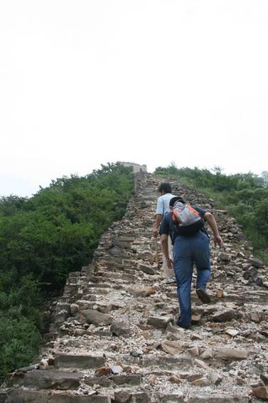 Mr. Chen and Pang Li hike up the eroded remains of the Great Wall of China. 