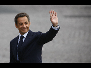 French President Nicolas Sarkozy waves during the France's Bastille Day military parade held in Paris, capital of France, on July 14, 2010.  [Xinhua]