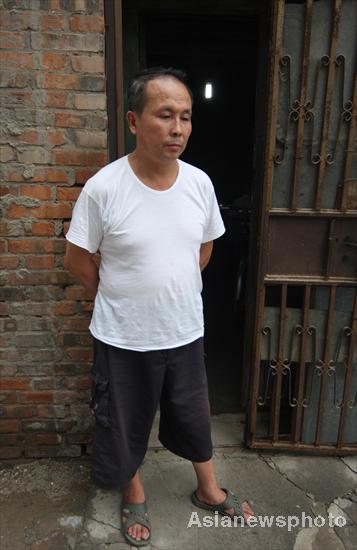 &apos;Nail house&apos; owner Zhang Changfu stands by his house in Beijing&apos;s downtown area, July 14, 2010. [Asianewsphoto]