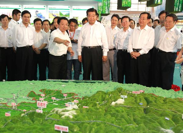 Jia Qinglin (C, front), chairman of the National Committee of the Chinese People's Political Consultative Conference, visits the exhibition of Sichuan Province during an achievements exhibition displaying China's western regions' environmental protection and construction accomplishments during the 'West Development' campaign, in Beijing, capital of China, July 14, 2010. [Xinhua]