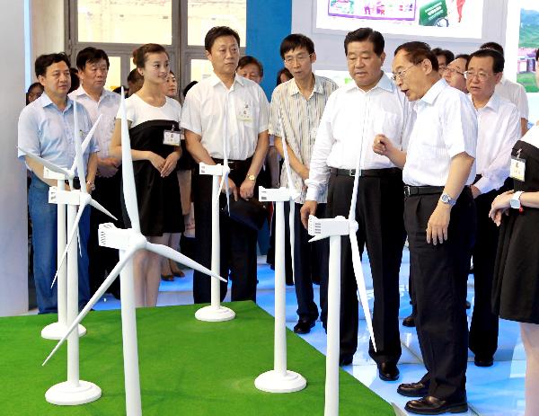 Jia Qinglin (2nd R, front), chairman of the National Committee of the Chinese People's Political Consultative Conference, visits the exhibition of Gansu Province during an achievements exhibition displaying China's western regions' environmental protection and construction accomplishments during the 'West Development' campaign, in Beijing, capital of China, July 14, 2010. [Xinhua]