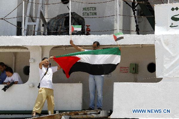 Crew members of the Libyan ship Al-Amal (Hope) wave Palestinian national flags as the ship arrives at El-Arish port, about 360 kilometers northeast of Cairo, capital of Egypt, on July 15, 2010. The Gaza-bound Libyan aid ship Al-Amal arrived at Egypt&apos;s el-Arish port on Thursday. On Tuesday, organizers of the Libyan-commissioned aid ship said Israeli naval forces have intercepted the ship, ordering it to head to Egypt. [Nasser Nouri/Xinhua]