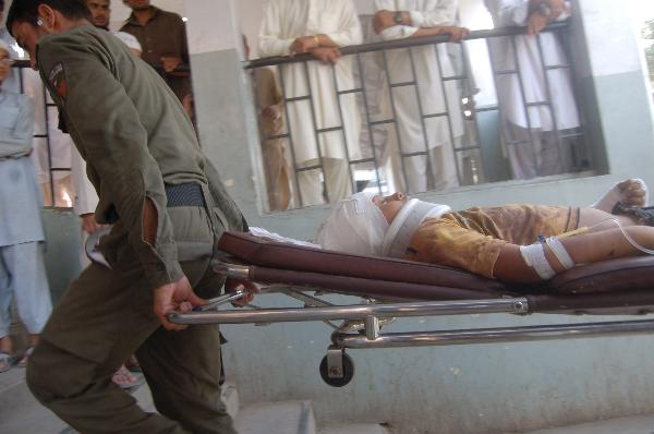 Security members send an injured to Peshawar&apos;s hospital in Pakistan, on July 15, 2010. Casualties in the suicide blast in Pakistan&apos;s northwest city of Mingora on Thursday have risen to 50, local media reported. [Saeed Ahmad/Xinhua]