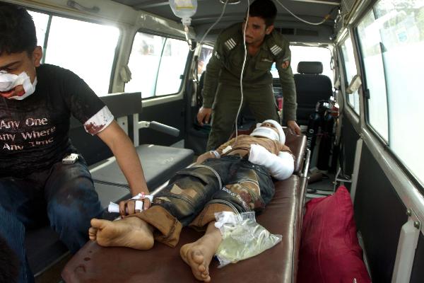 Security members send an injured to Peshawar&apos;s hospital in Pakistan, on July 15, 2010. Casualties in the suicide blast in Pakistan&apos;s northwest city of Mingora on Thursday have risen to 50, local media reported. [Saeed Ahmad/Xinhua]