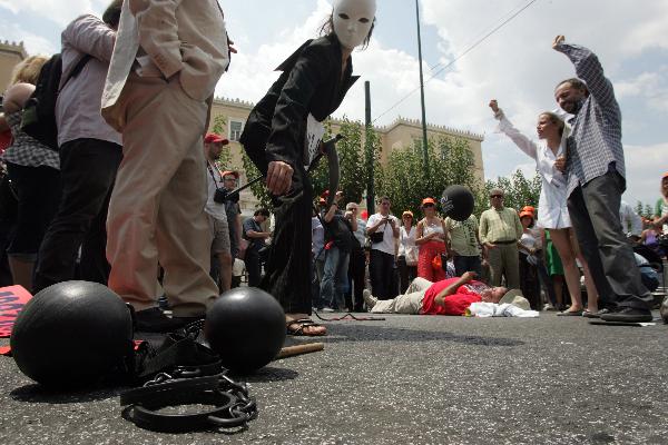 Greek civil servants stage a theatrical performance during a demonstration to protest against the austerity measures and the reform of the pension system in Athens, capital of Greece, July 15, 2010. The umbrella labor union of public sector employees in Greece staged a four-hour work stoppage, as the parliament was due to approve the bill presented by the Greek government as a vital step to face a severe economic crisis. [Marios Lolos/Xinhua]