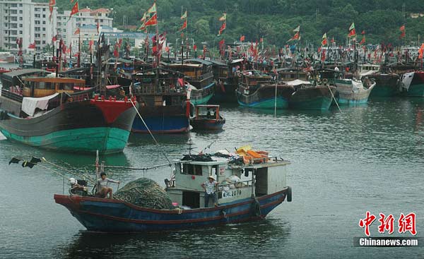 Fishing boats are lined up at a port in Haikou, capital of Hainan province, July 15, 2010. China issued an orange alert for wave surges, the second highest level warning, forecasting that Typhoon Conson may reach land Friday on the southeast coast of China' s Hainan province, July 15, 2010.More than 24,000 boats have docked at the port in response to local authorities' warning of the approaching typhoon. [Xinhua]