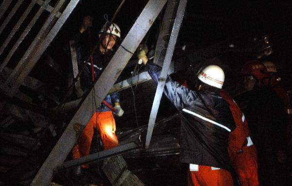 Firefighters rescue a man trapped by billboards blowed off by Typhoon Conson in Sanya City, south China's island province of Hainan, July 16, 2010. Typhoon Conson landed at Yalong Bay of Sanya City late Friday, causing casualties.[Jiang Tieying/Xinhua]