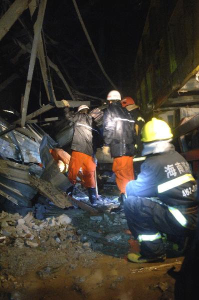 Firefighters rescue a man trapped by billboards blowed off by Typhoon Conson in Sanya City, south China's island province of Hainan, July 16, 2010. Typhoon Conson landed at Yalong Bay of Sanya City late Friday, causing casualties.[Jiang Tieying/Xinhua] 