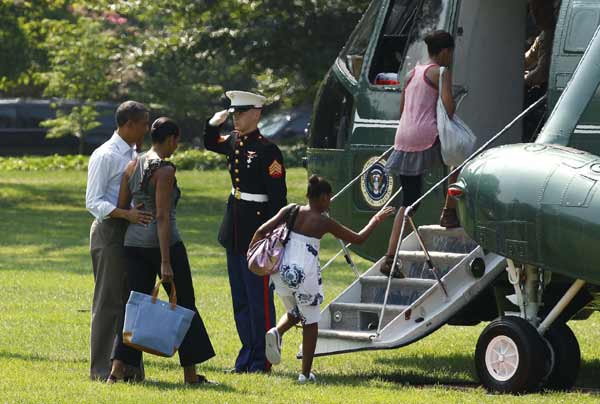 U.S. President Barack Obama puts his arm around first lady Michelle while daughters Sasha (L) and Malia (R) board Marine One as the first family departs from the White House in Washington for their trip to Maine, July 16, 2010. [Xinhua]