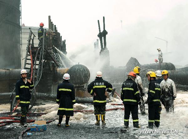 Firefighters work at the scene where a blast took place in Dalian, a coastal city in northeast China&apos;s Liaoning Province, July 16, 2010. Flames that engulfed a port in Dalian were basically extinguished Saturday morning, 15 hours after blasts hit two oil pipelines. The fire and explosion caused no casualties. [Li Gang/Xinhua]