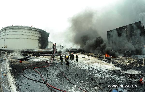 Firefighters work at the scene where a blast took place in Dalian, a coastal city in northeast China&apos;s Liaoning Province, July 16, 2010. Flames that engulfed a port in Dalian were basically extinguished Saturday morning, 15 hours after blasts hit two oil pipelines. The fire and explosion caused no casualties. [Li Gang/Xinhua]