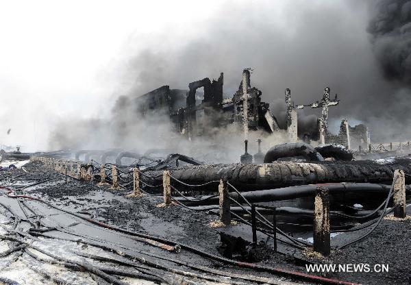 Firefighters work at the scene where a blast took place in Dalian, a coastal city in northeast China&apos;s Liaoning Province, July 16, 2010. Flames that engulfed a port in Dalian were basically extinguished Saturday morning, 15 hours after blasts hit two oil pipelines. The fire and explosion caused no casualties. [Li Gang/Xinhua]