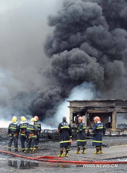 Firefighters work at the scene where a blast took place in Dalian, a coastal city in northeast China&apos;s Liaoning Province, July 16, 2010. Flames that engulfed a port in Dalian were basically extinguished Saturday morning, 15 hours after blasts hit two oil pipelines. The fire and explosion caused no casualties. [Li Gang/Xinhua]