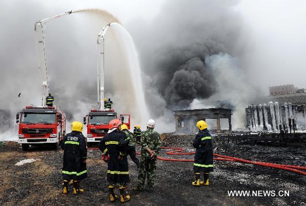 Firefighters work at the scene where a blast took place in Dalian, a coastal city in northeast China&apos;s Liaoning Province, July 16, 2010. Flames that engulfed a port in Dalian were basically extinguished Saturday morning, 15 hours after blasts hit two oil pipelines. The fire and explosion caused no casualties. [Li Gang/Xinhua]