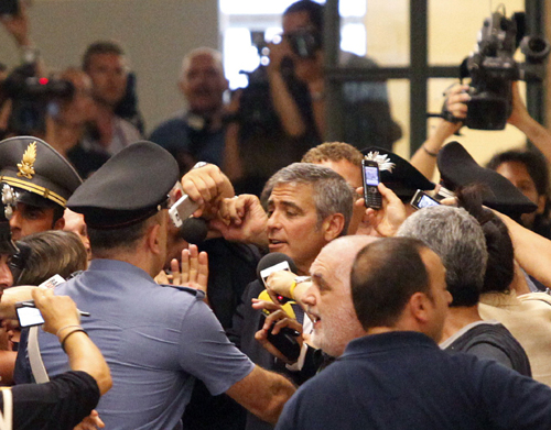 Hollywood actor George Clooney (C) is surrounded by a crowd as he leaves the court in Milan July 16, 2010. Clooney testified on Friday at a trial of three people accused of exploiting his name to promote a fashion brand in Milan. 