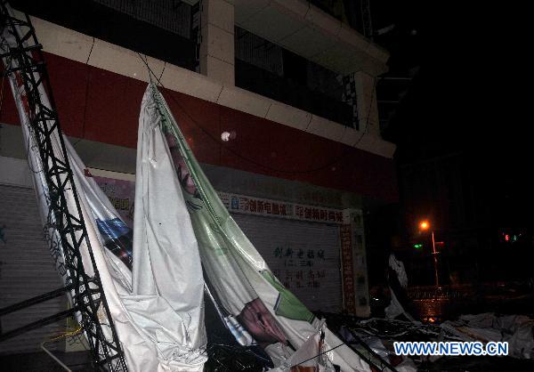 An ad board is pulled down by Typhoon Conson in Sanya, a coastal resort in south China&apos;s Hainan Province, late July 16, 2010. Typhoon Conson made its powerful landfall in the Yalong Bay in Sanya Friday night, causing serious damages.