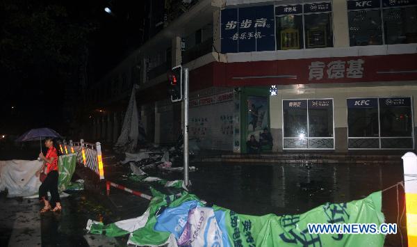 An ad board is pulled down by Typhoon Conson in Sanya, a coastal resort in south China&apos;s Hainan Province, late July 16, 2010. Typhoon Conson made its powerful landfall in the Yalong Bay in Sanya Friday night, causing serious damages. 