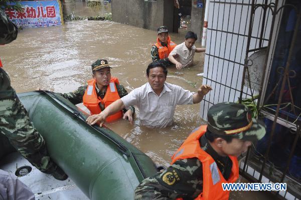Firemen evacuate stranded residents in Guangshui City, central China&apos;s Hubei Province, July 17, 2010. The city was flooded by torrential downpour from Friday evening to Saturday morning.[Xinhua]