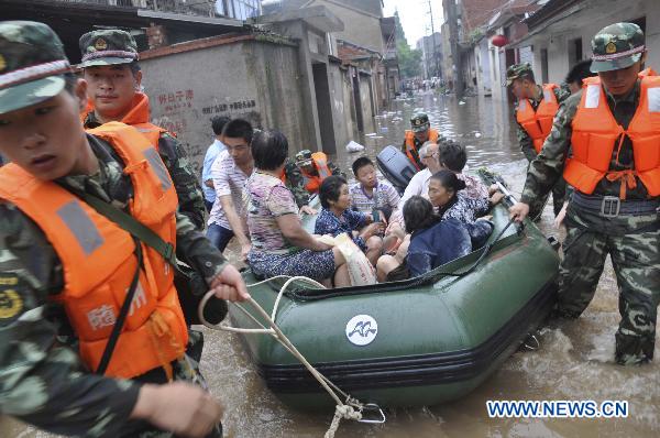 Firemen evacuate stranded residents in Guangshui City, central China&apos;s Hubei Province, July 17, 2010. The city was flooded by torrential downpour from Friday evening to Saturday morning. [Xinhua]