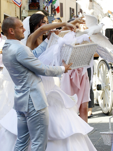 Inter Milan&apos;s Dutch player Wesley Sneijder and his wife Yolanthe release white doves after their marriage ceremony at a church in Castelnuovo Berardenga, about 15km (9 miles) from Siena July 17, 2010. [Xinhua]