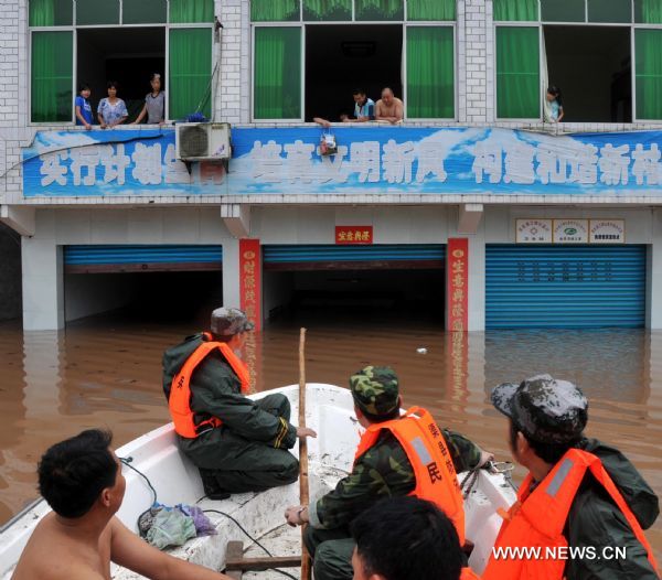 Soldiers on a speed boat transfer villagers trapped by flood water at Shanxing Village of Qu County in Dazhou City, southwest China&apos;s Sichuan Province, July 18, 2010. A torrential flood swept the county on Sunday. The flood peak level was 4.66 meters higher than the safe line. (Xinhua/Wu Tao) (mcg) 
