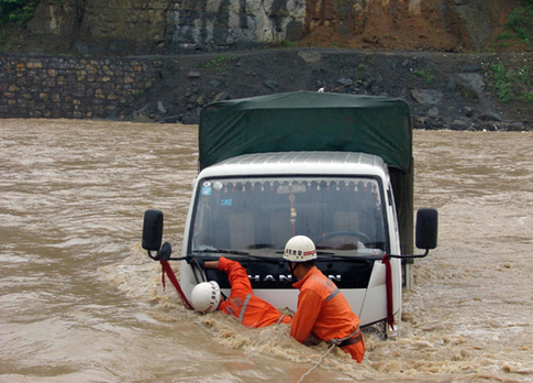 Rescue workers make sure whether there are people trapped in a vehicle in Tongnan, Southwest China&apos;s Chongqing municipality on July 18, 2010. [Xinhua] 