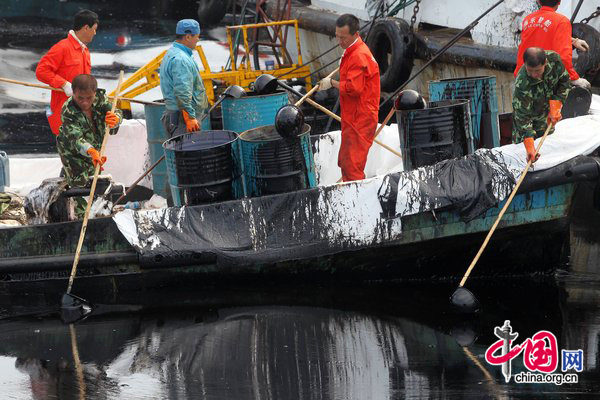Efforts were under way July 18 to contain and clean up a large oil slick after pipeline explosions at northeastern China&apos;s Dalian Xingang port. Maritime workers on 20 boats were sent to install fencing to stop the spilled oil from spreading further in Dalian&apos;s Xingang Harbor. [CFP] 
