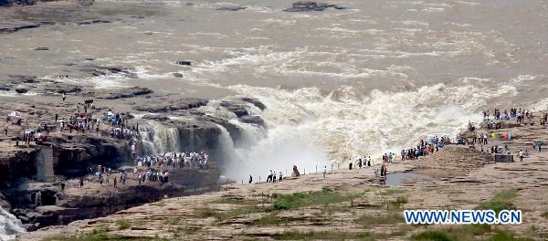 Tourists admire the spectacular torrents of the Hukou Waterfall on the Yellow River, resulting from upriver precipitation, near Jixian County, northern China's Shanxi Province, July 17, 2010. [Xue Jun/Xinhua] 