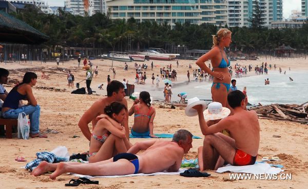 Visitors enjoy themselves on the Dadonghai Beach in Sanya City, south China's Hainan Province, July 17, 2010. Tourism has got recovery as Typhoon Conson has weakened after sweeping the tropical island of Hainan on Friday evening. [Jiang Tieying/Xinhua]