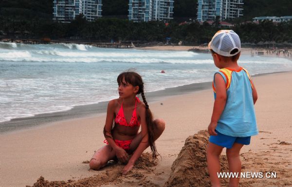 Visitors enjoy themselves on the Dadonghai Beach in Sanya City, south China's Hainan Province, July 17, 2010. Tourism has got recovery as Typhoon Conson has weakened after sweeping the tropical island of Hainan on Friday evening. [Jiang Tieying/Xinhua]