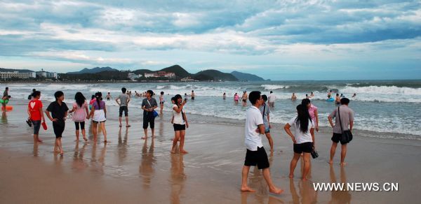 Visitors enjoy themselves on the Dadonghai Beach in Sanya City, south China's Hainan Province, July 17, 2010. Tourism has got recovery as Typhoon Conson has weakened after sweeping the tropical island of Hainan on Friday evening. [Jiang Tieying/Xinhua]