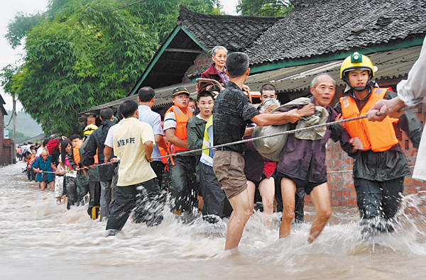 More than 70 firefi ghters in Leshan city of Sichuan province evacuate more than 1,000 farmers trapped by floods on Sunday. Continuous rainstorms inundated four villages in Jianong town of Leshan’s Shawan district on Sunday. [China News Service]
