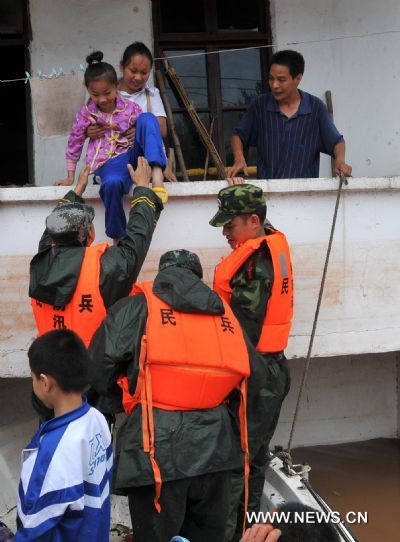 Soldiers transfer villagers trapped by flood water at Shanxing Village of Qu County in Dazhou City, southwest China&apos;s Sichuan Province, July 18, 2010. A torrential flood swept the county on Sunday. The flood peak level was 4.66 meters higher than the safe line. [Xinhua]