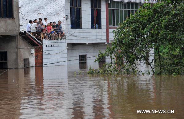 Soldiers on a speed boat transfer villagers trapped by flood water at Shanxing Village of Qu County in Dazhou City, southwest China&apos;s Sichuan Province, July 18, 2010. A torrential flood swept the county on Sunday. The flood peak level was 4.66 meters higher than the safe line. [Xinhua]