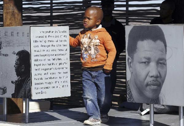 A boy stands next to a picture of former South Africa&apos;s president Nelson Mandela at a museum in Mvezo during former president Mandela&apos;s 92nd birthday celebrations, about 70km from Mthatha, in the Eastern Cape July 18, 2010.[Xinhua/Reuters]