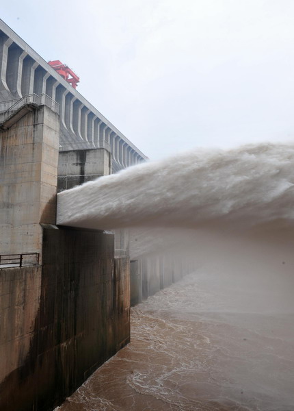 Floodwater rushes through the sluice gates of the Three Gorges Dam in Yichang, central China&apos;s Hubei province on July 19, 2010. [Xinhua]