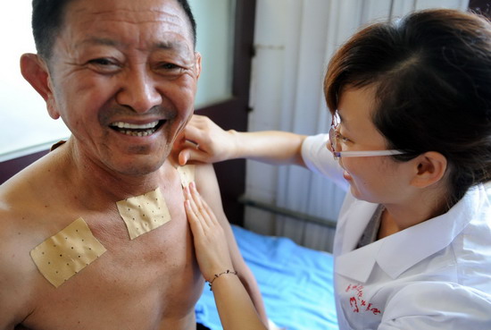 An old man gets medical plasters in Huatuo Chinese Medicine Hospital on the first day of &apos;toufu&apos; in Haozhou city, east China&apos;s An&apos;hui province on July 19, 2010. [Xinhua]