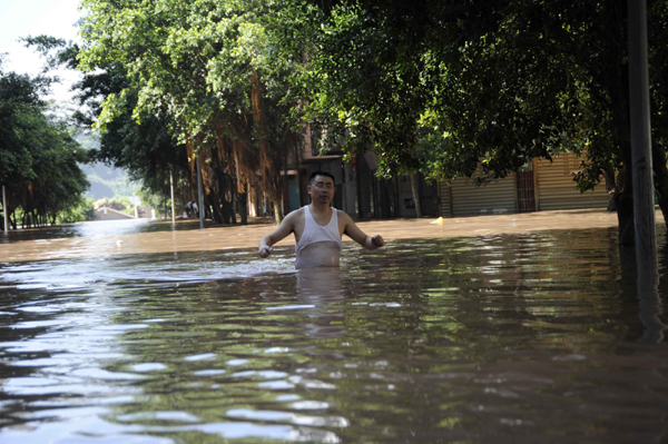 A man waits for help in flood waters in Guang&apos;an, Southwest China&apos;s Sichuan province on July 19, 2010. [Xinhua] 