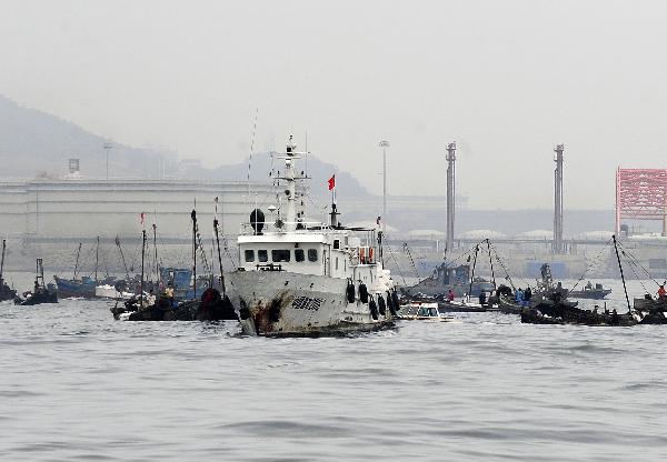 Boats carry out cleaning work in the area affected by oil spill in Dalian, a coastal city in northeast China&apos;s Liaoning Province on July 19, 2010. More than 500 fishing boats were set off Monday to clean up the crude oil that gushed into the sea after an oil pipe exploded at Dalian Xingang Harbor. Another 4 patrol boats kept monitoring the diffusion of oil and cleaning work, while laying out more protective boom.