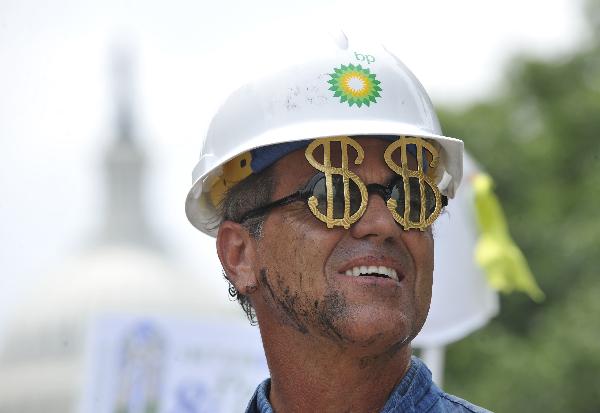 Activists hold placards during a protest to mark the three-month anniversary of the Deepwater Horizon oil rig explosion before the Capitol Hill in Washington D.C., capital of the United States, July 20, 2010. British Prime Minister David Cameron, on his first official visit to Washington, on Tuesday tried to appease the massive rage at BP company, which was blamed for the responsibility for the Gulf of Mexico oil disaster. [Zhang Jun/Xinhua]