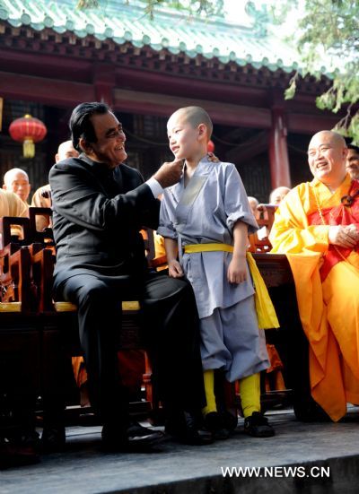 Sri Lankan Prime Minister D.M. Jayaratne (L) talks to a little monk at the Shaolin Temple located on Songshan Mountain in central China&apos;s Henan Province, July 20, 2010. Jayaratne visited the world-renowned Shaolin Temple on Tuesday. The 1,500-year-old temple is regarded as one of the holy sites of Chinese Kungfu.[Zhu Xiang/Xinhua]