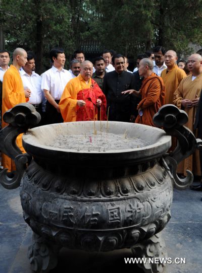 Sri Lankan Prime Minister D.M. Jayaratne (4th R, front) listens to introduction in front of an incense burner in the Shaolin Temple located on Songshan Mountain in central China&apos;s Henan Province, July 20, 2010. Jayaratne visited the world-renowned Shaolin Temple on Tuesday. The 1,500-year-old temple is regarded as one of the holy sites of Chinese Kungfu. [Zhu Xiang/Xinhua]